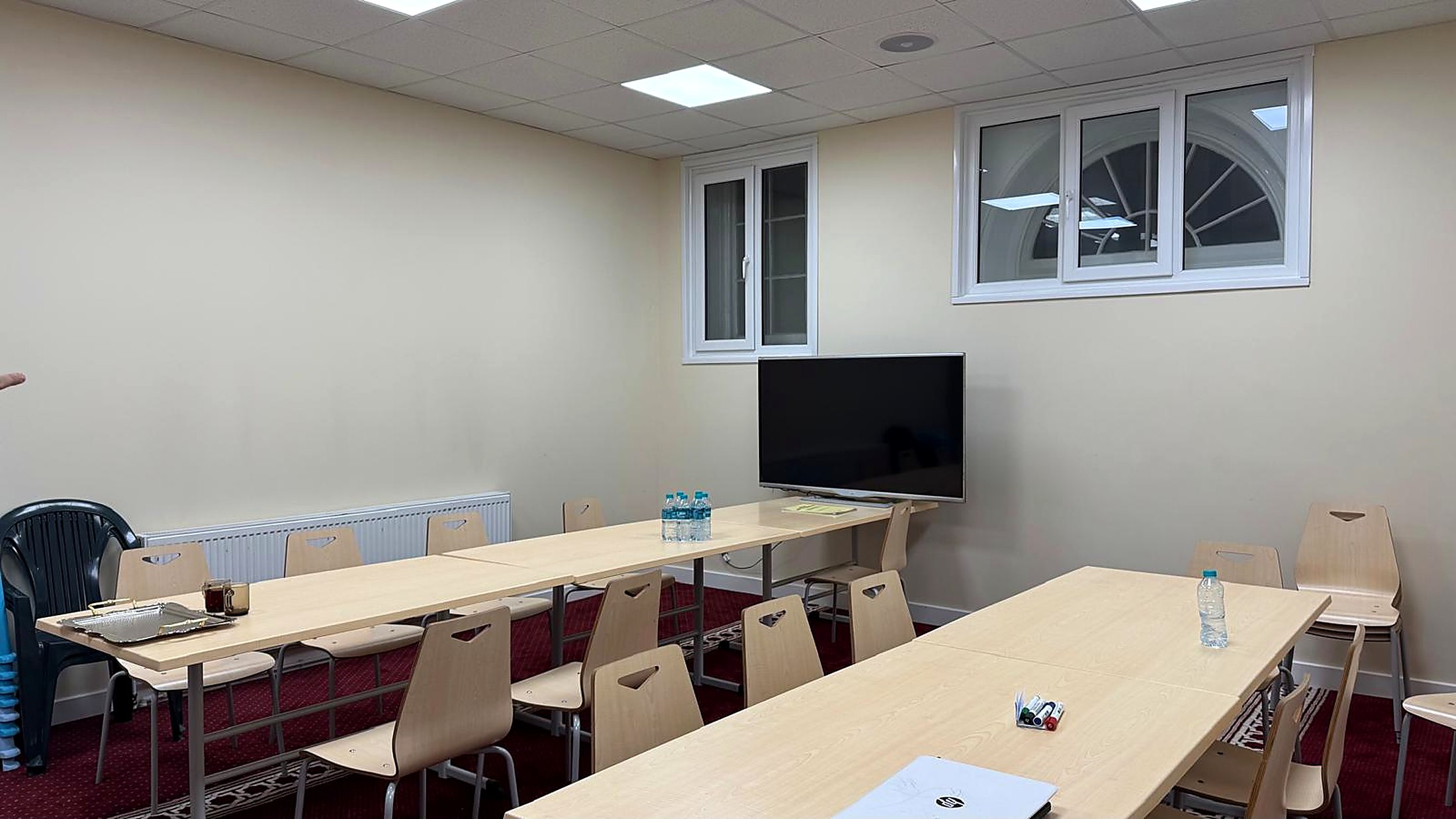 A meeting room set up with tables and a screen